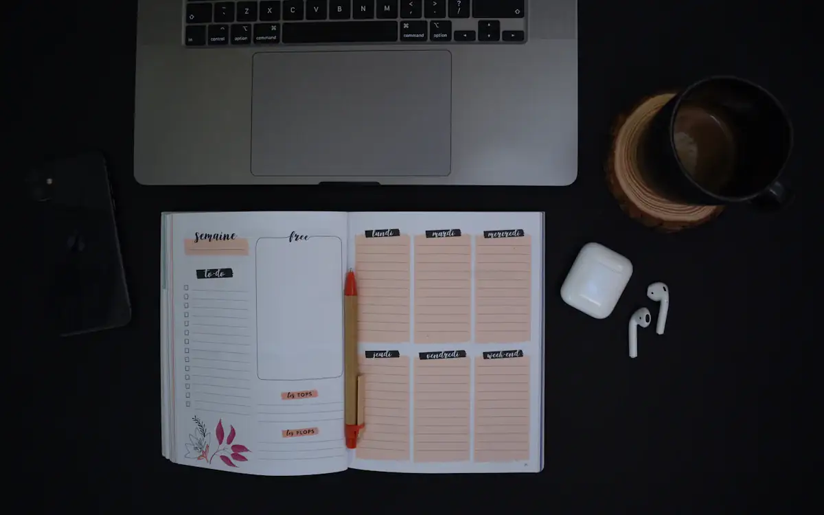A weekly planner open on a dark desk