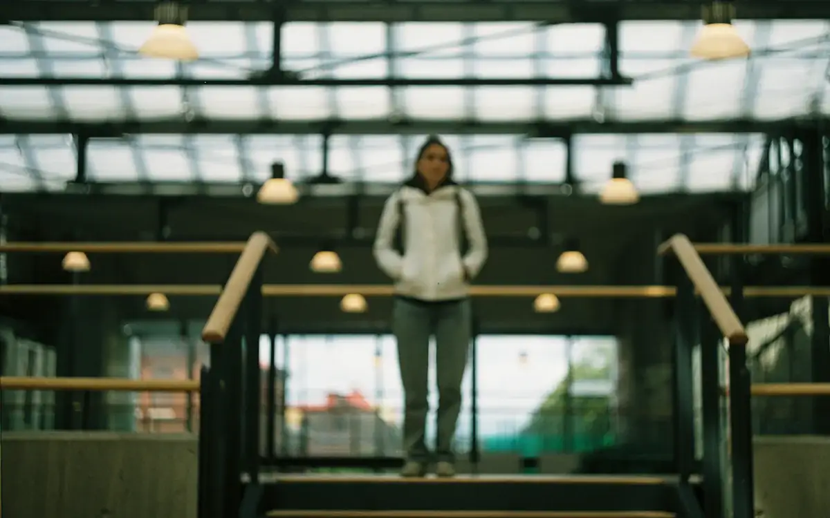 A person on a staircase inside a glass building