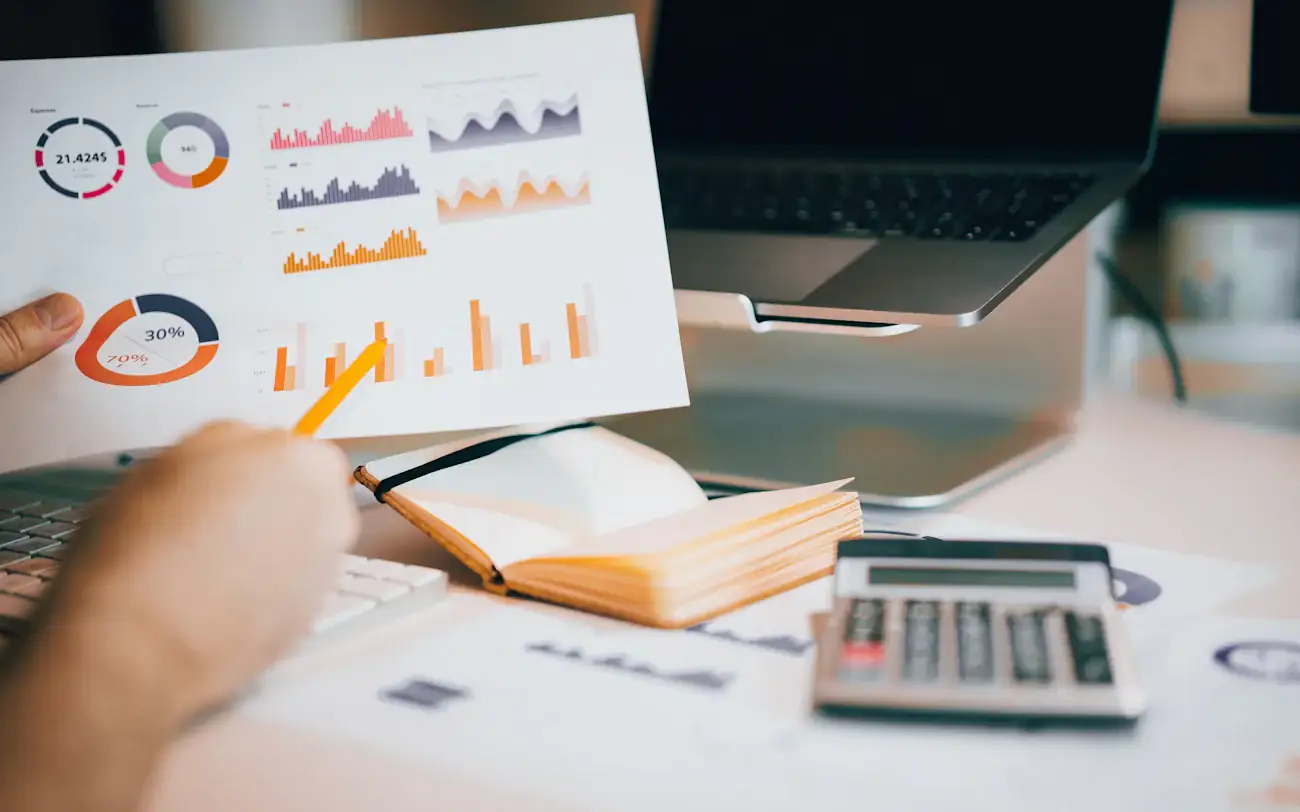 Printed charts held over a laptop